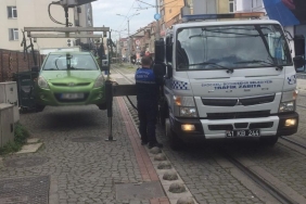 Tramvay yoluna park edilen araçlar çekiliyor